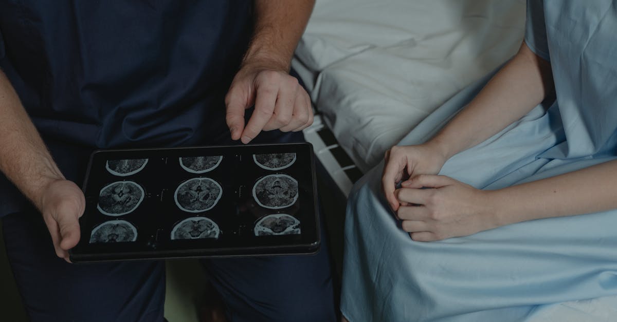 A doctor consults with a patient, using a tablet to show electronic health records and explain a treatment plan.