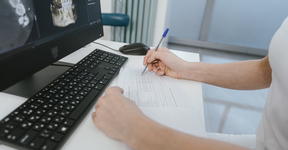 Close-up of a doctor analyzing a patient's EMR chart on a computer screen.
