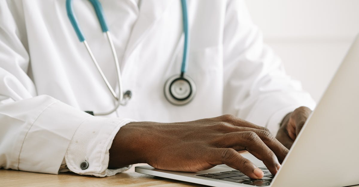 Close-up of a clinic receptionist's hands typing on a keyboard, using a sophisticated clinic management software.